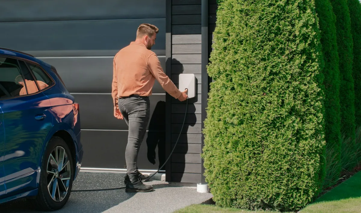 Řidič zapojuje služební elektromobil k nabíjení u domu